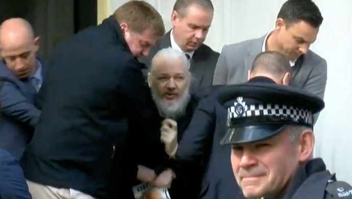 Julián Assange al momento de ser detenido en Londres.